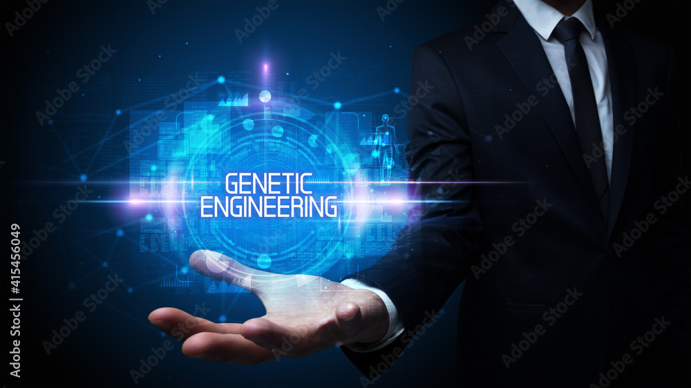 Man hand holding GENETIC ENGINEERING inscription, technology concept Man hand holding GENETIC ENGINEERING inscription, technology concept