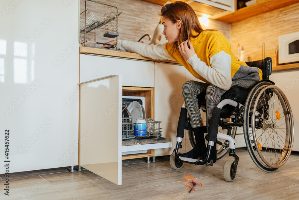 Female in wheelchair doing usual daily chores Female in wheelchair doing usual daily chores