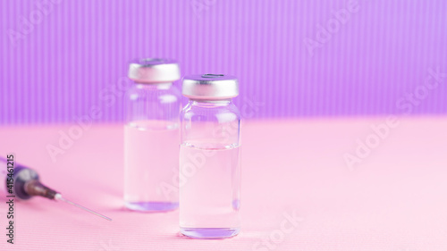 Vaccines and syringe on a pink purple background for prevention and immunization. Vaccine and syringe injection. Medical concept. Copy space