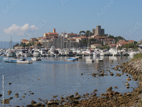 Panorama of the fortified medieval village of Talamone and of its coast lapped by the Tyrrhenian Sea with the boats moored in the port
