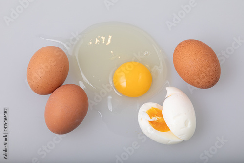 Top view of raw and boiled chicken eggs on white background
