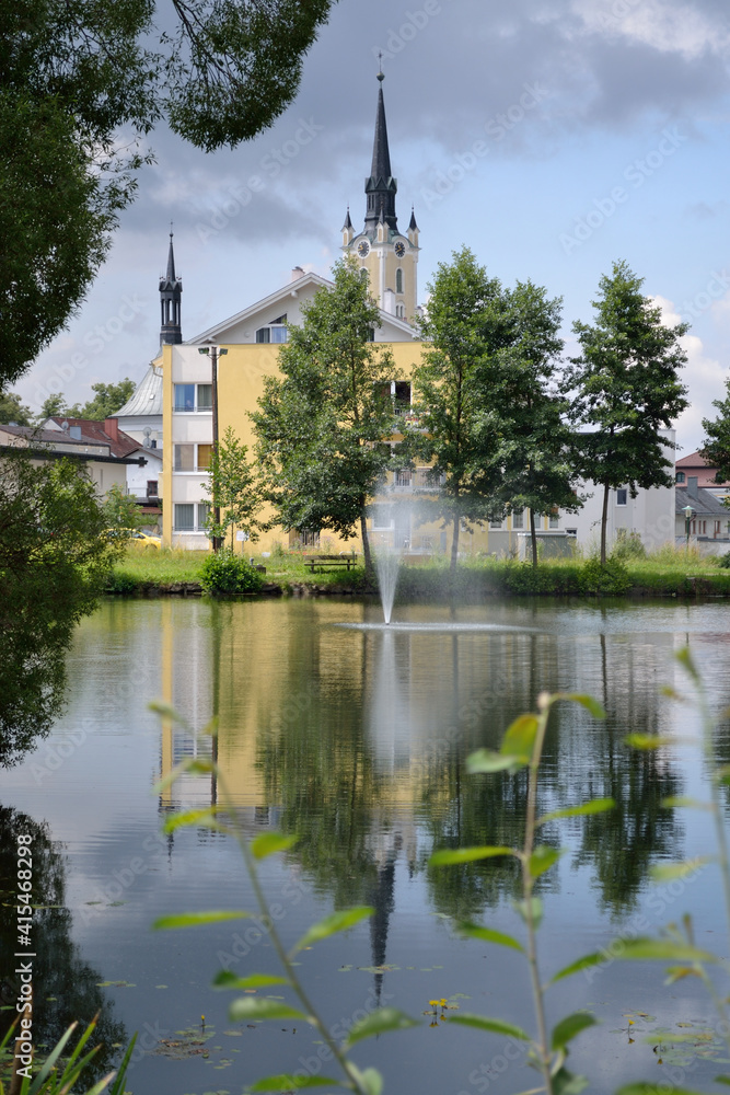 Church Spire And Another Is Reflected In A Pond