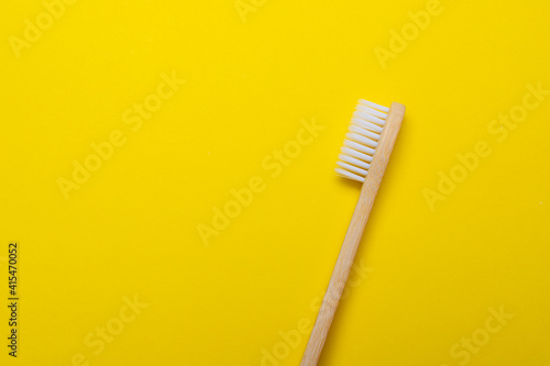Bamboo brush on a yellow background. No plastic. Ecology. Taking care of the world around you. Toothbrush. Clean teeth. Yellow background. Copy space. of the environment.