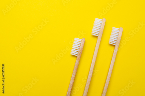 Bamboo brush on a yellow background. No plastic. Ecology. Taking care of the world around you. Toothbrush. Clean teeth. Yellow background. Copy space. of the environment.