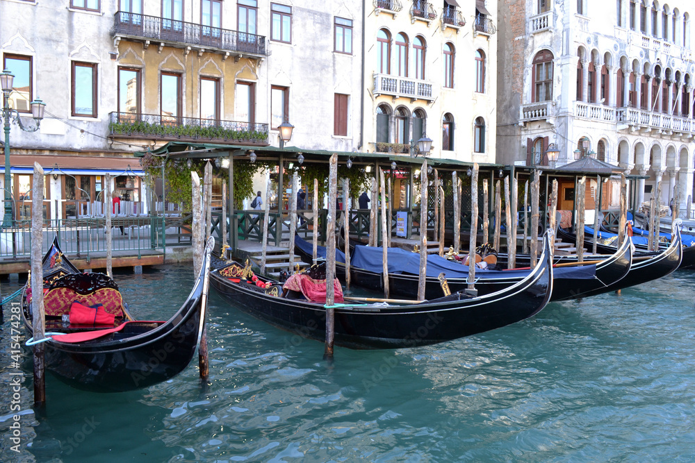 Typical view of the Venetian canal with gondolas and old houses. 