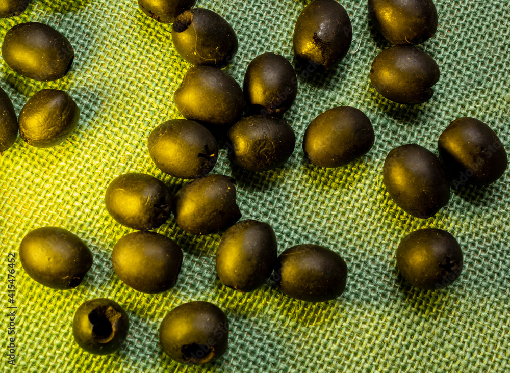dark olives lit up through a bottle of oil