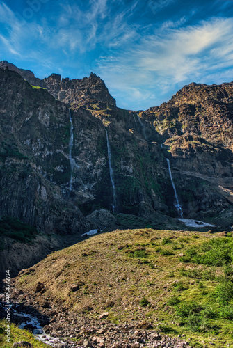 waterfall and cliffs with sunset light and clouds