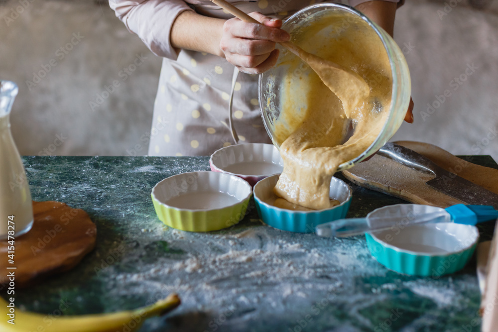 Woman pouring batter from bowl into baking mould for pie. Woman pouring batter from bowl into baking mould for pie.