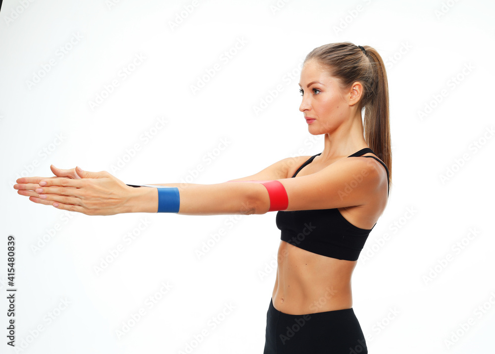 Sportswoman performs exercises for the muscles of the hands. Photo of woman workout with resistance band on white background. Strength and motivation. Sportswoman performs exercises for the muscles of the hands. Photo of woman workout with resistance band on white background. Strength and motivation.