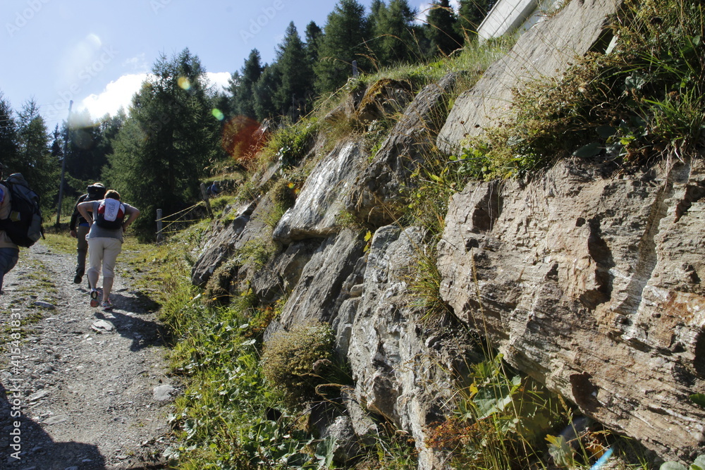Wanderer gehen den langen Weg entlang in der Schweiz. Bergen und Felsen in der Schweiz Wanderer gehen den langen Weg entlang in der Schweiz. Bergen und Felsen in der Schweiz
