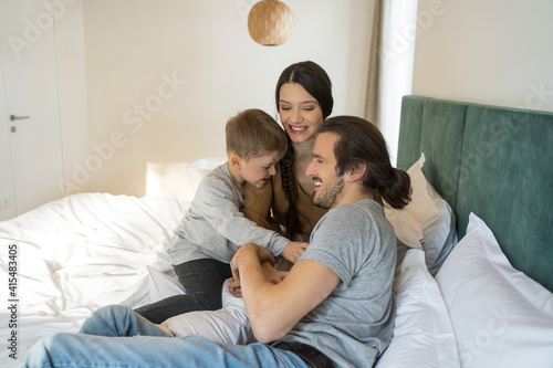 Family sitting together at the bed while playing