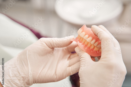 Dentist holding dentures in her hands photo