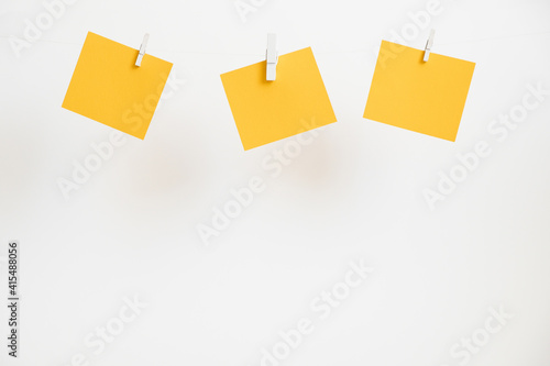 Yellow stickers on clothespins on white background. Copyspace for text.