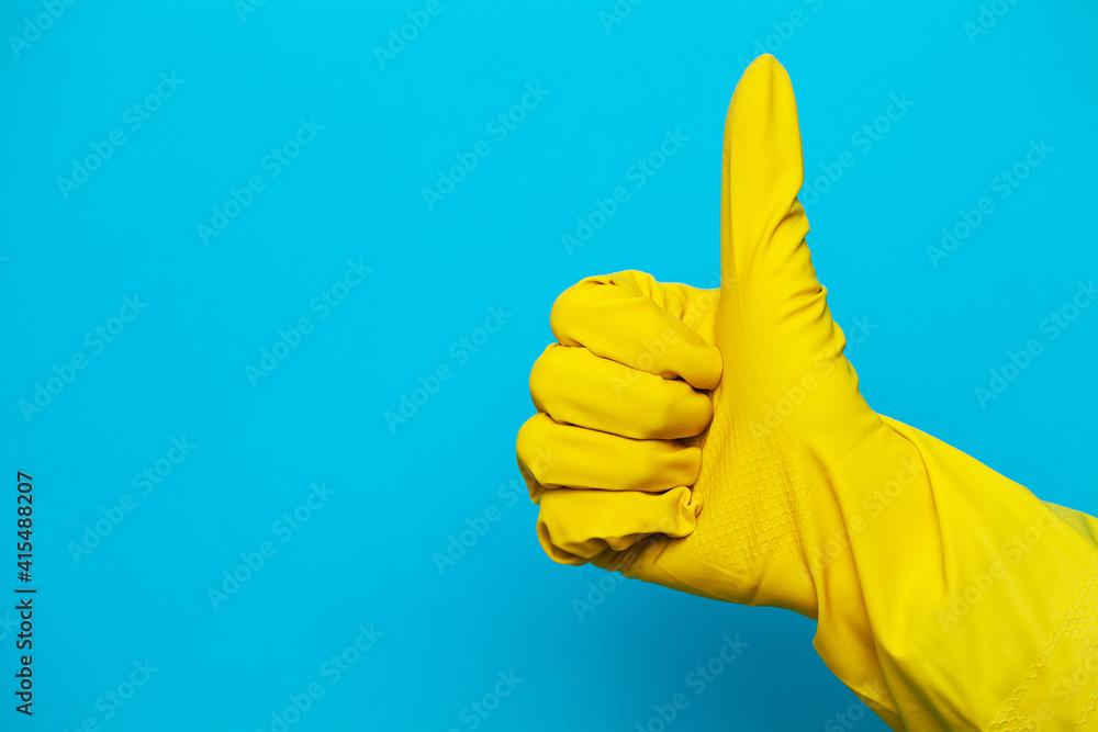 yellow glove for cleaning on womans arm show thumbs up