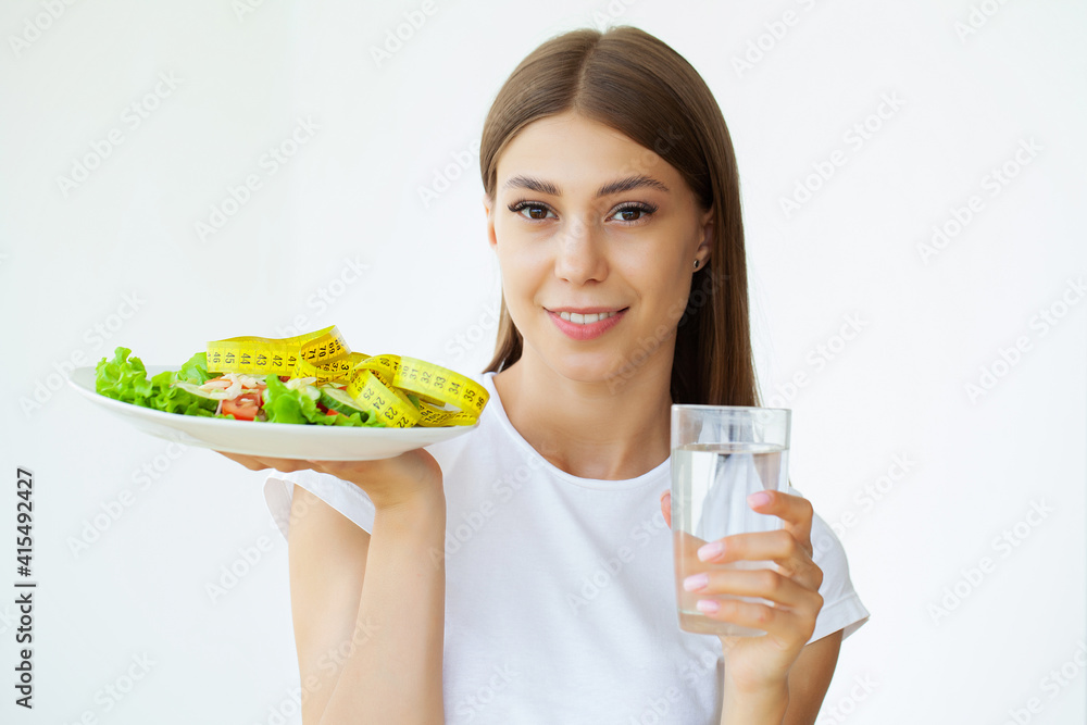 Young woman hold healthy salad with green fresh ingredients and yellow tape Young woman hold healthy salad with green fresh ingredients and yellow tape