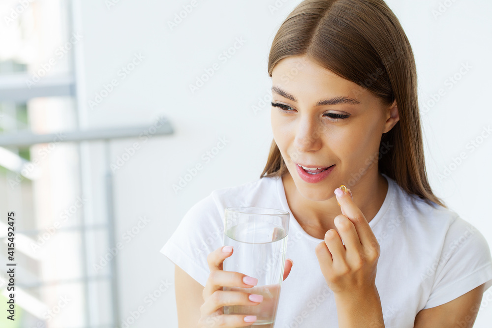 Portrait of smiling young woman with Omega 3 fish oil capsule Portrait of smiling young woman with Omega 3 fish oil capsule