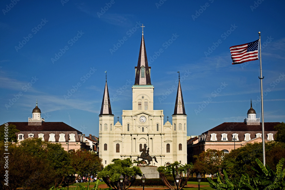 View of St. Louis Cathedral across Jackson Square with American flag waving in the wind. New Orleans, Louisiana