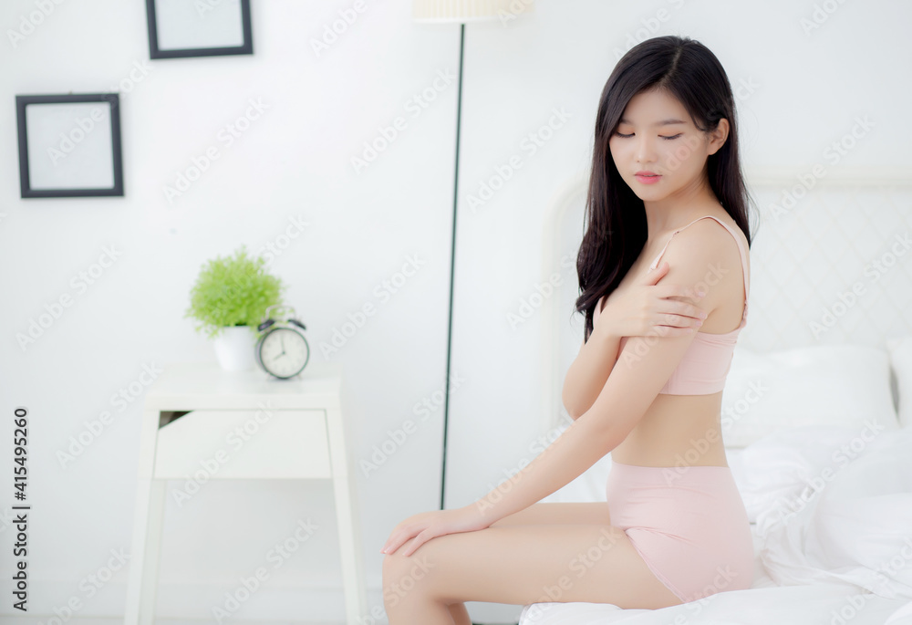 Beautiful young asian woman applying moisturizer with makeup of cosmetic, girl hand touch shoulder cream and lotion attractive, beauty perfect with wellness in the bedroom with skin care concept. Beautiful young asian woman applying moisturizer with makeup of cosmetic, girl hand touch shoulder cream and lotion attractive, beauty perfect with wellness in the bedroom with skin care concept.