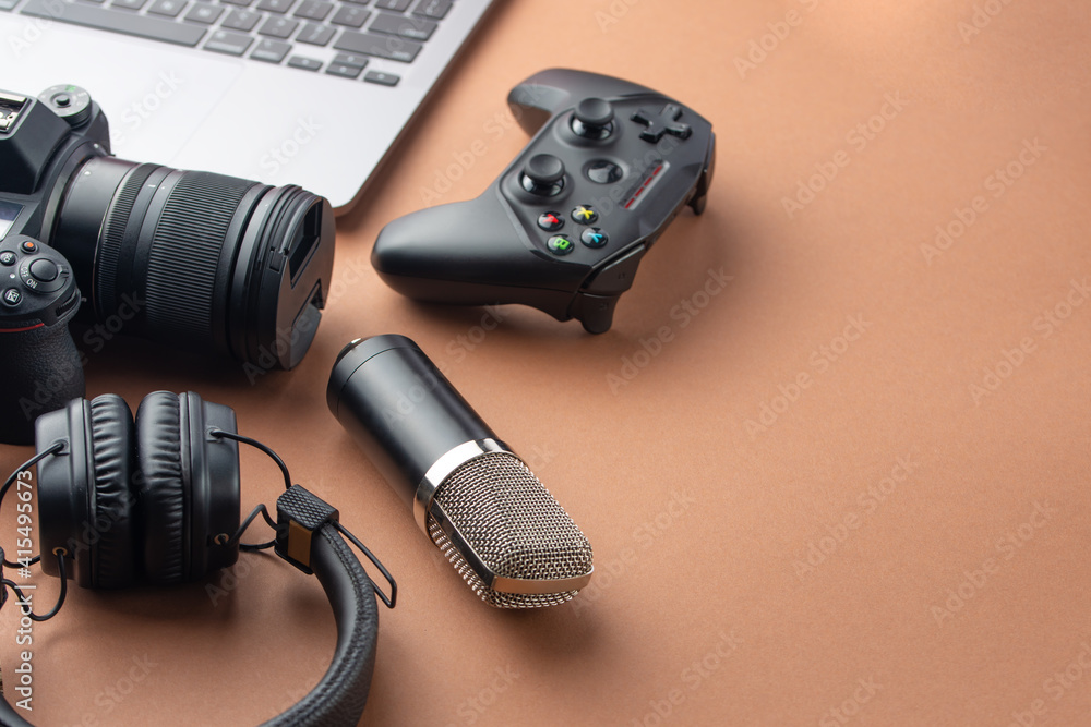 Camera, joystick or gamepad, headphones, microphone and laptop, top view. Modeling and blogging, broadcasting games and donation. With space for inscription Camera, joystick or gamepad, headphones, microphone and laptop, top view. Modeling and blogging, broadcasting games and donation. With space for inscription