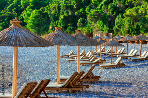 Pebble beach with sun umbrellas and loungers photo