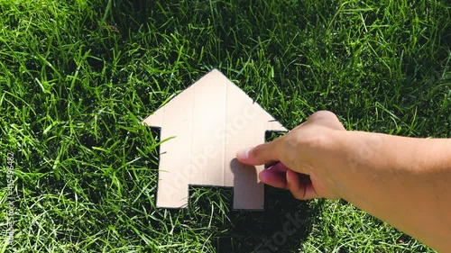 green home and eco-friendly construction, house icon on green grass lawn under the sun with garden bokeh photo