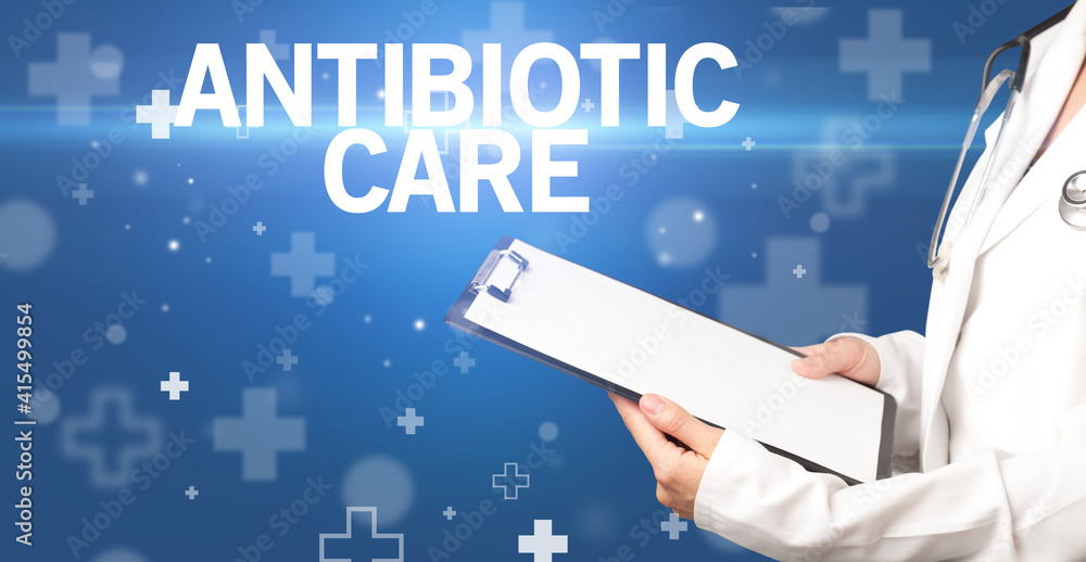 doctor writes notes on the clipboard with ANTIBIOTIC CARE inscription, first aid concept doctor writes notes on the clipboard with ANTIBIOTIC CARE inscription, first aid concept