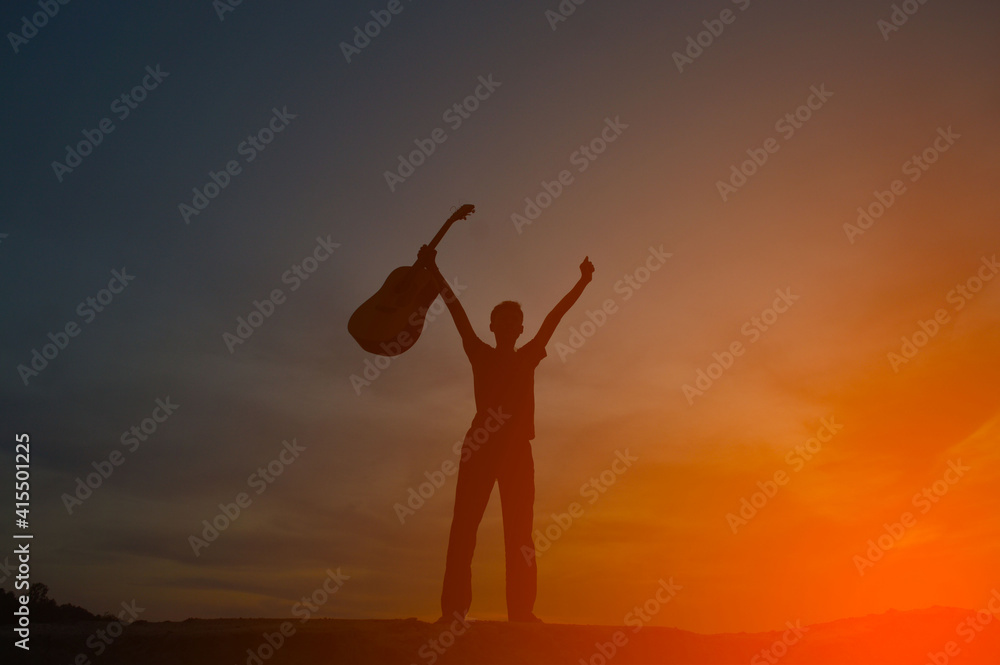 A silhouette of a man holding a guitar holding hands