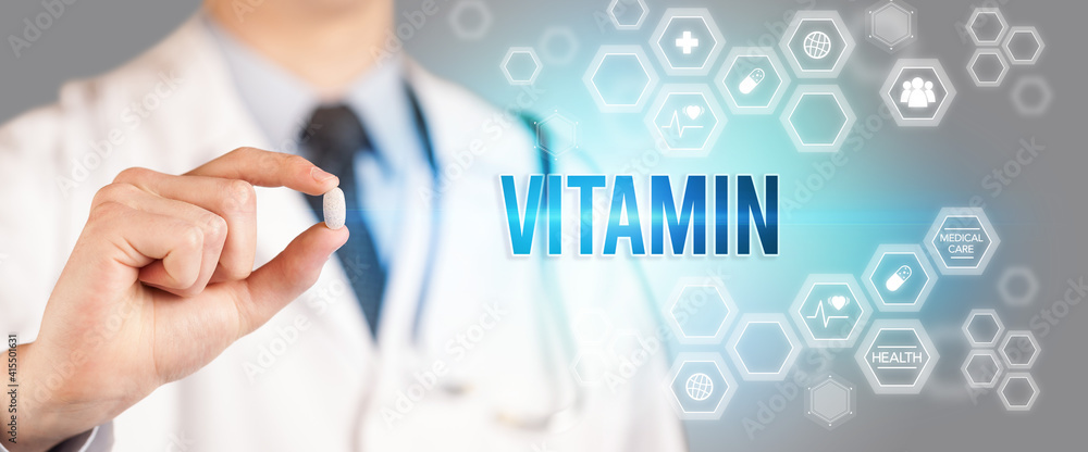 Close-up of a doctor giving you a pill with VITAMIN inscription, medical concept Close-up of a doctor giving you a pill with VITAMIN inscription, medical concept