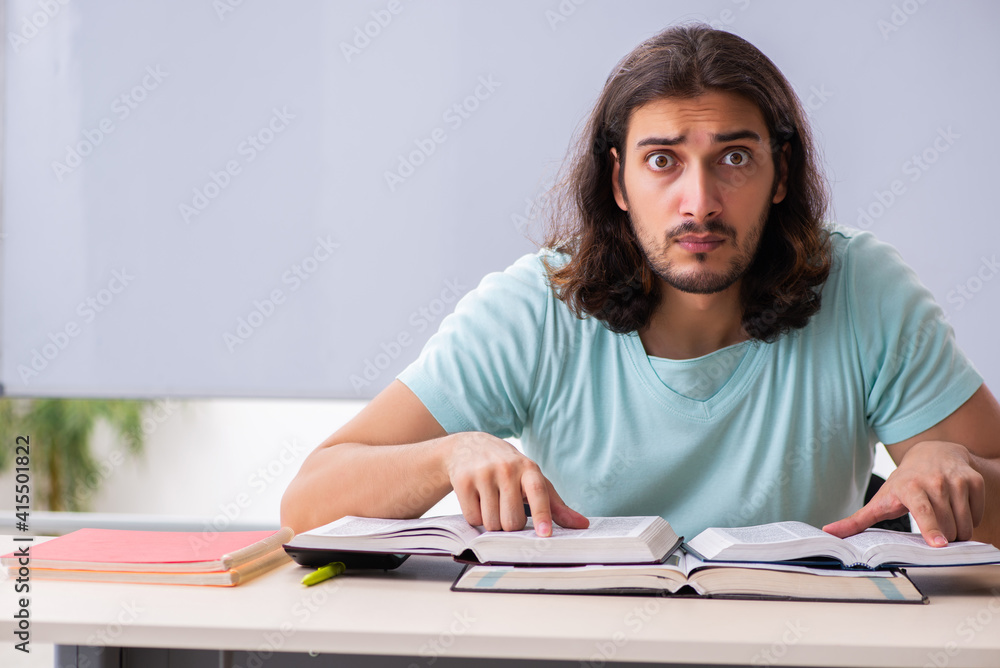 Young male student preparing for exams in the classroom Young male student preparing for exams in the classroom