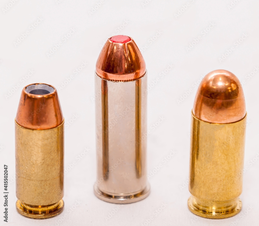 Three bullets, a 9mm, 45 caliber and a 44 special on a white background Three bullets, a 9mm, 45 caliber and a 44 special on a white background
