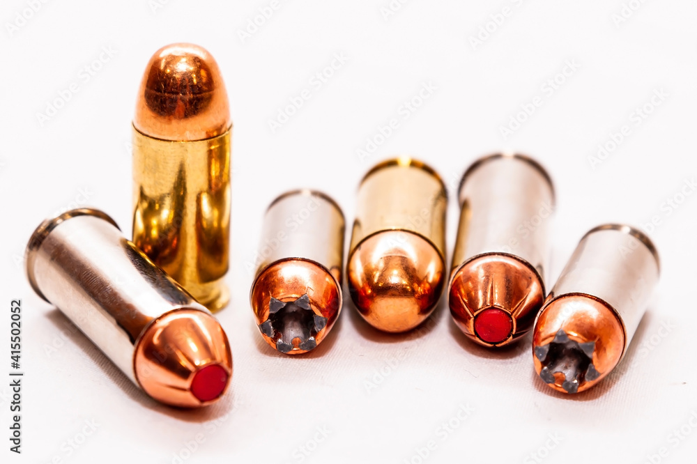 Six bullets, hollow point and full metal jackets, 45 caliber, 9mm and 44 special lined up on a white background Six bullets, hollow point and full metal jackets, 45 caliber, 9mm and 44 special lined up on a white background