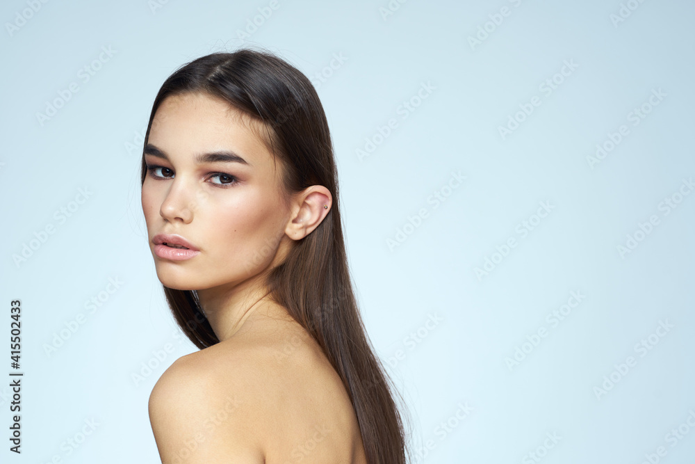 Woman with naked shoulders long hair clean skin cropped view blue background Woman with naked shoulders long hair clean skin cropped view blue background