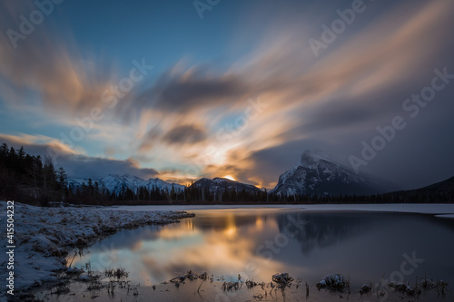 Long exposure sunrise landscape of mountains with snow reflected on water during a cold morning winter under a cloudy sky  Vermilion Lakes  Mount Rundle  Banff National Park  Alberta  Canada