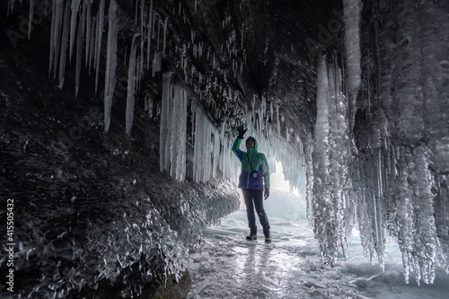 A tourist admires icicles in an ice grotto on Lake Baikal