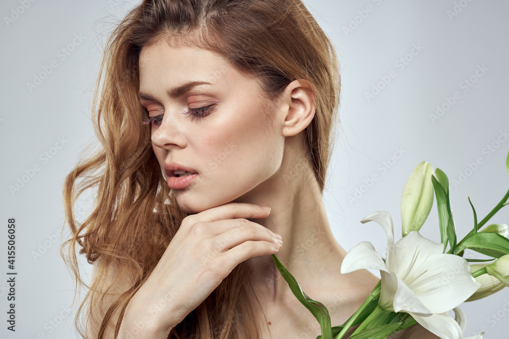 Emotional woman with flowers spring model naked shoulders clear skin Emotional woman with flowers spring model naked shoulders clear skin