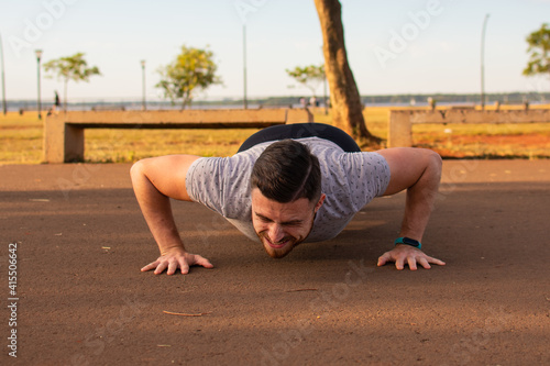 joven haciendo flexiones de brazos , haciendo ejercicio  photo