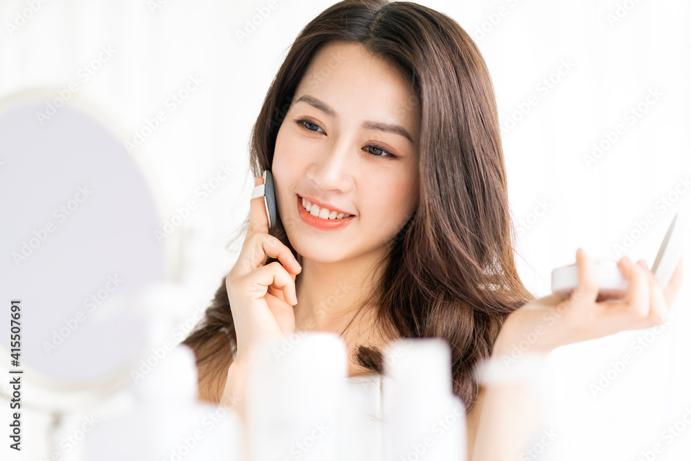 Asian woman sitting makeup in front of mirror Asian woman sitting makeup in front of mirror