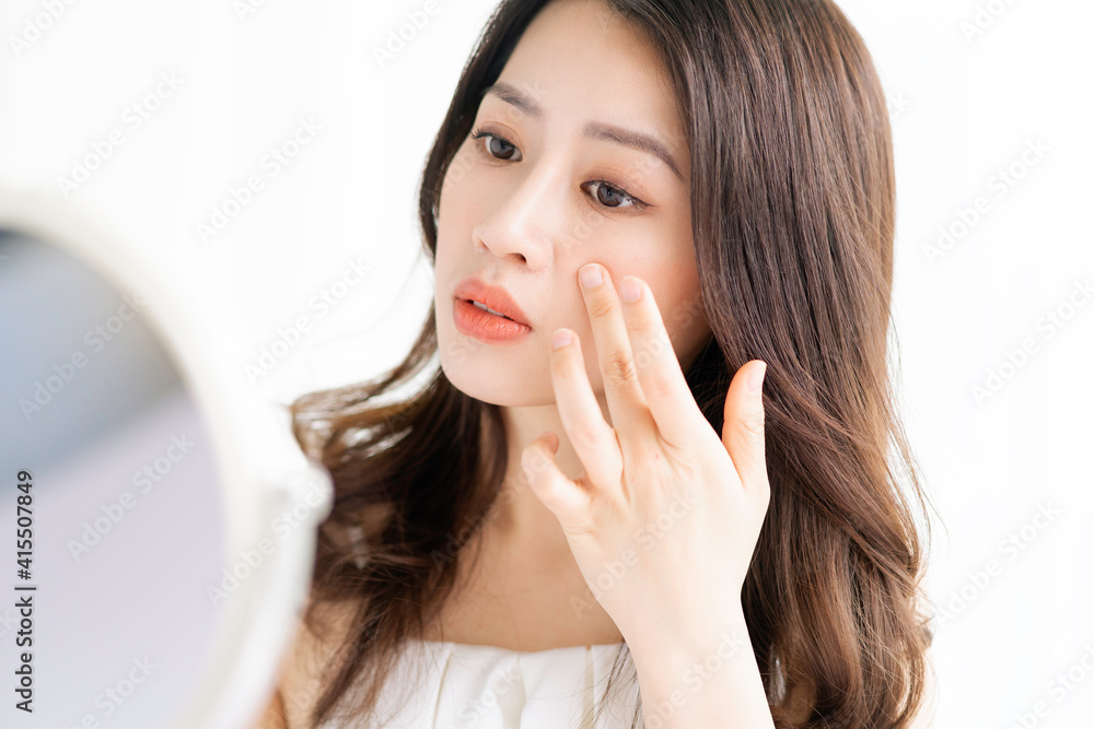 Asian woman sitting makeup in front of mirror Asian woman sitting makeup in front of mirror