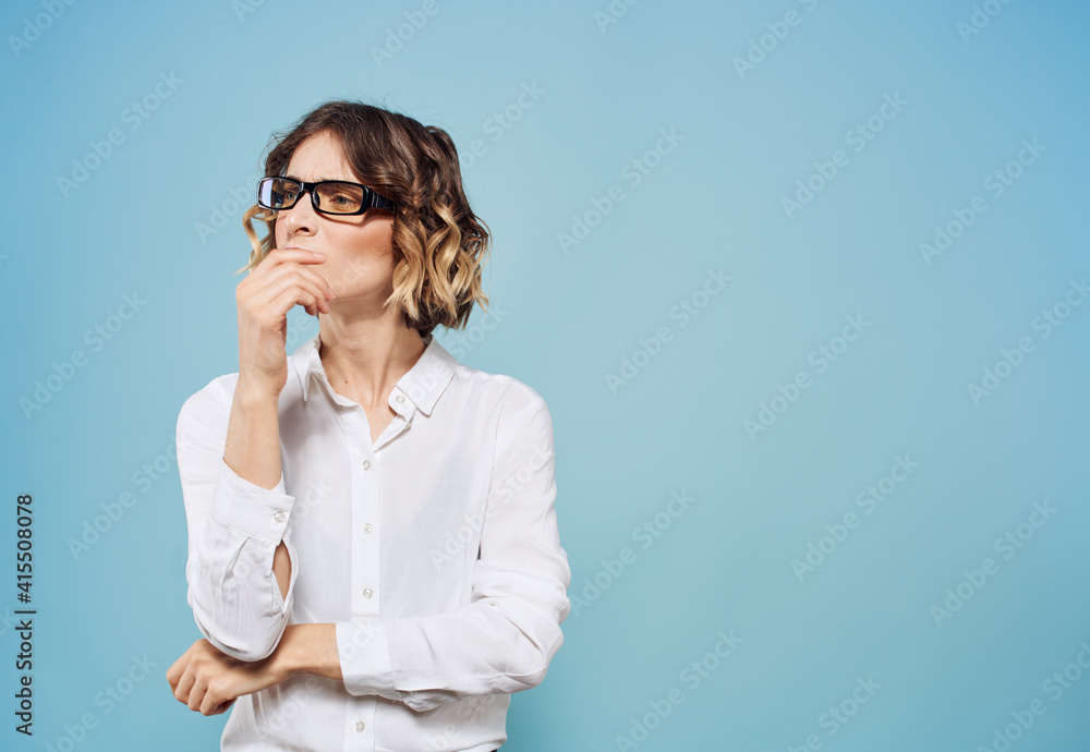 Woman model in white shirt gestures with hands emotions and stress blue background Woman model in white shirt gestures with hands emotions and stress blue background