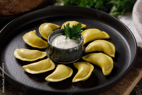 Appetizing traditional Russian dumplings made by hand with delicious filling. Still life on a wooden board. Close-up. photo