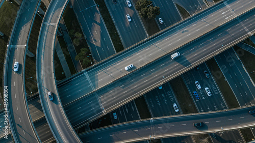 Top up aerial drone view of elevated road and traffic junctions in Chinese metropolis city Chengdu during sunny day. Modern construction design of traffic ways to avoid traffic jams. Few vehicles.
