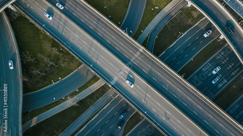 Top up aerial drone view of elevated road and traffic junctions in Chinese metropolis city Chengdu during sunny day. Modern construction design of traffic ways to avoid traffic jams. Few vehicles.