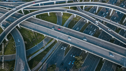 Top up aerial drone view of elevated road and traffic junctions in Chinese metropolis city Chengdu during sunny day. Modern construction design of traffic ways to avoid traffic jams. Few vehicles.