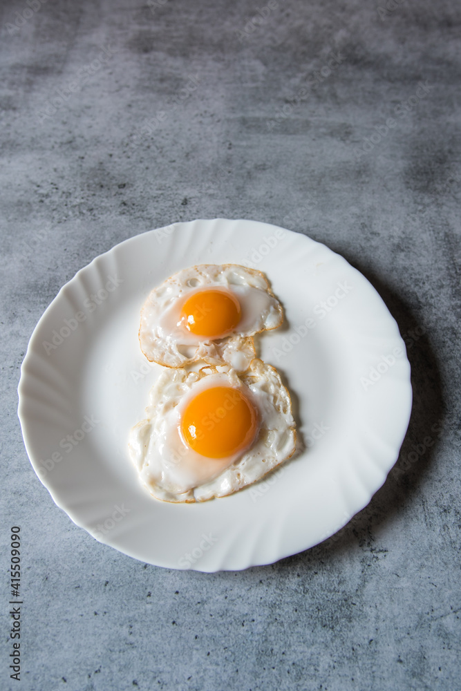 Egg poach sunny side up a healthy food ingredient on a plate. View from top, selective focus. Egg poach sunny side up a healthy food ingredient on a plate. View from top, selective focus.