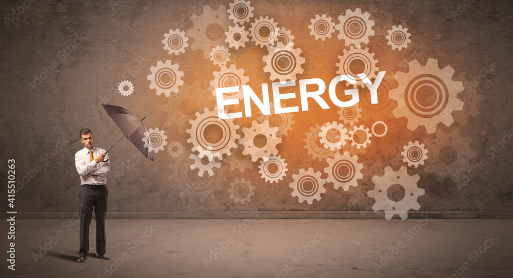 Businessman defending with umbrella from ENERGY inscription, technology concept Businessman defending with umbrella from ENERGY inscription, technology concept