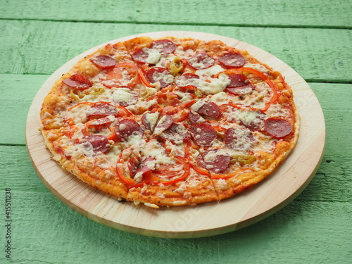 pizza on a wooden green background. Italian kitchen