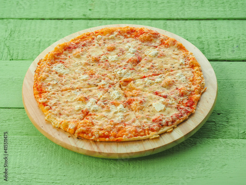 pizza on a wooden green background. Italian kitchen