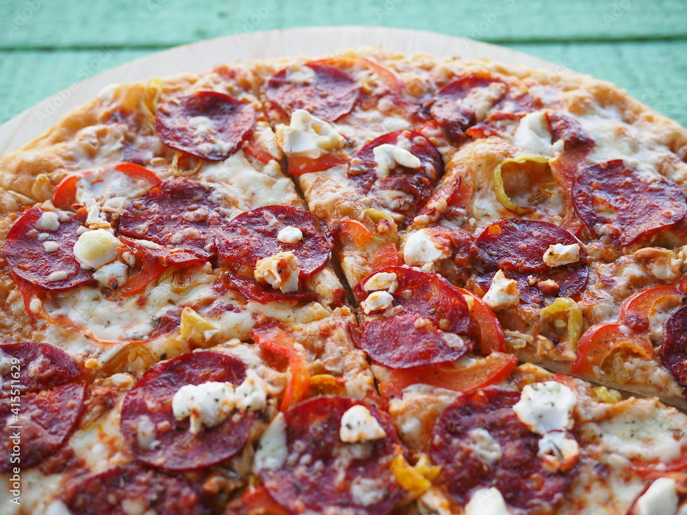 pizza on a wooden green background. Italian kitchen pizza on a wooden green background. Italian kitchen
