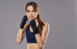 Woman boxer in gloves on gray background cropped view of brunette model