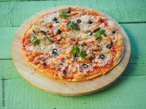 pizza on a wooden green background. Italian kitchen